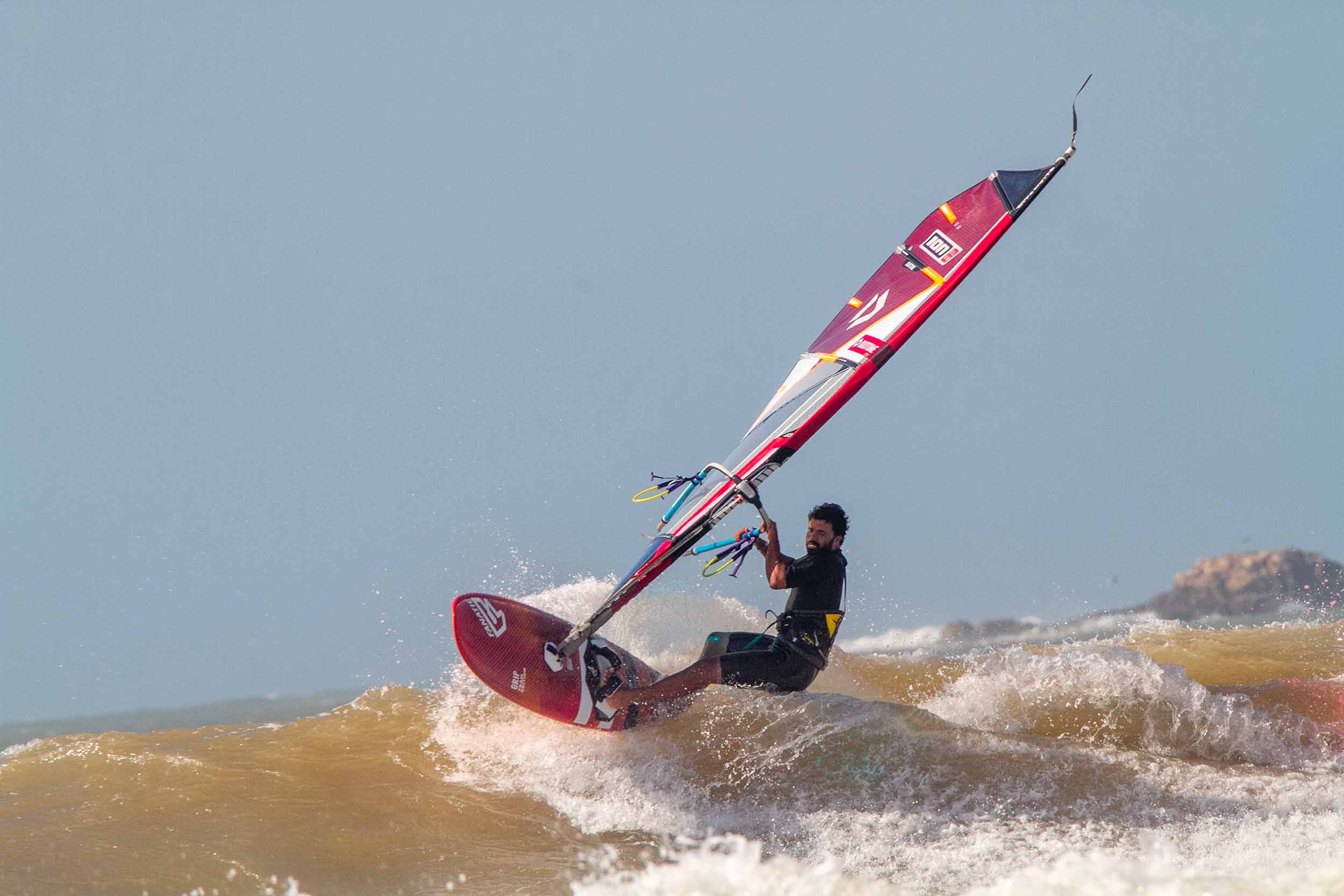 A WINDSRUFER IN THE WAVES IN FRONT OF ION CLUB ESSAOUIRA