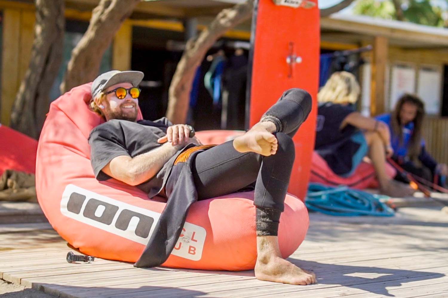 kids in a kitesurf storage doing his homework smiling