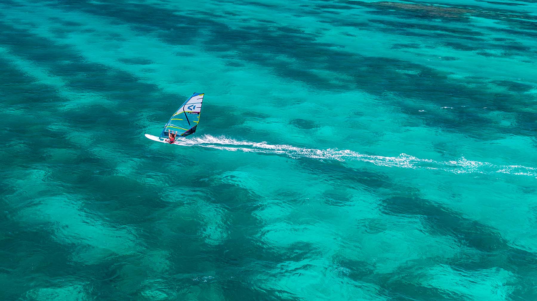 A WINDSURFER ON THE WATER IN MAURITIUS