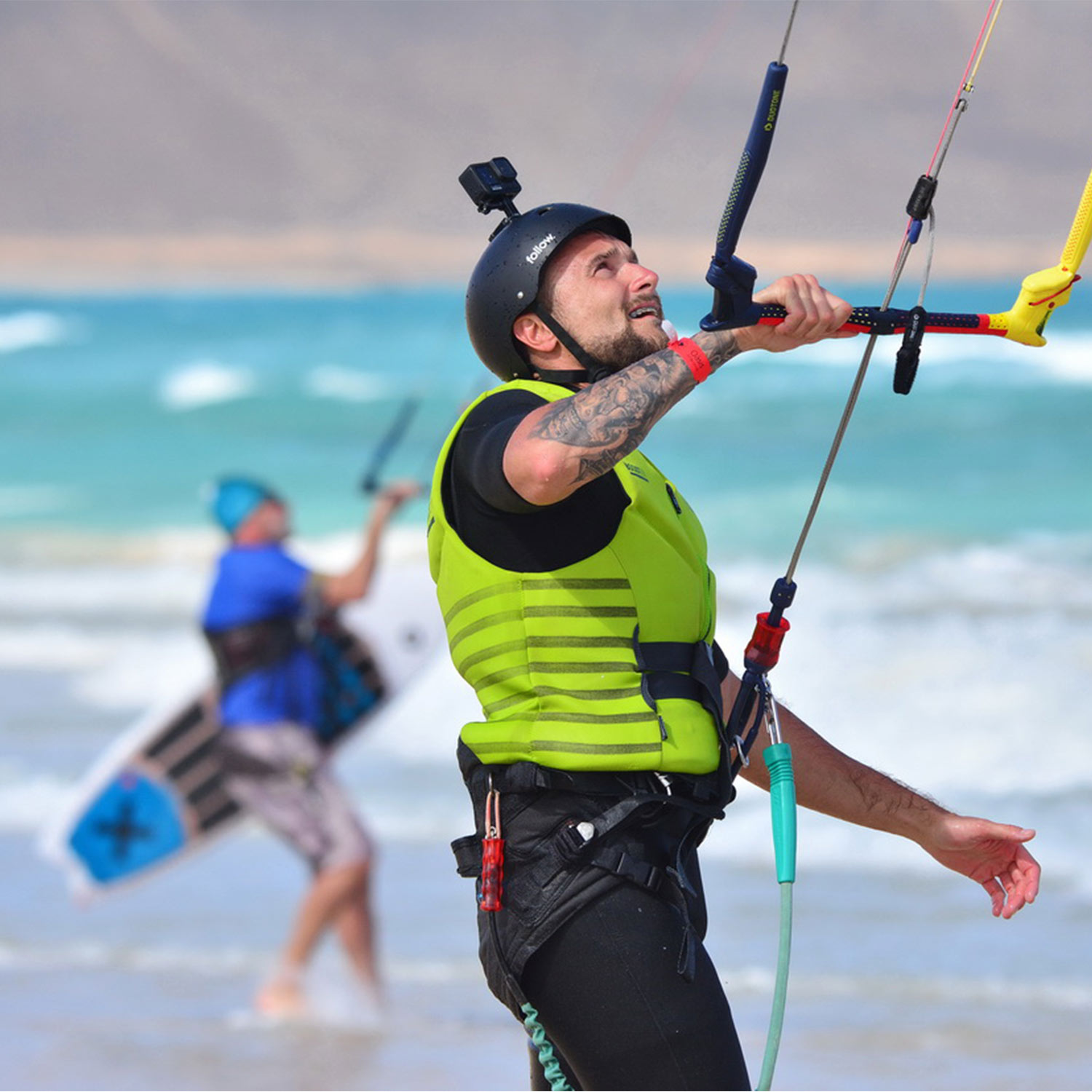 élève en kitesurf qui entre dans l'eau avec le kite à la main