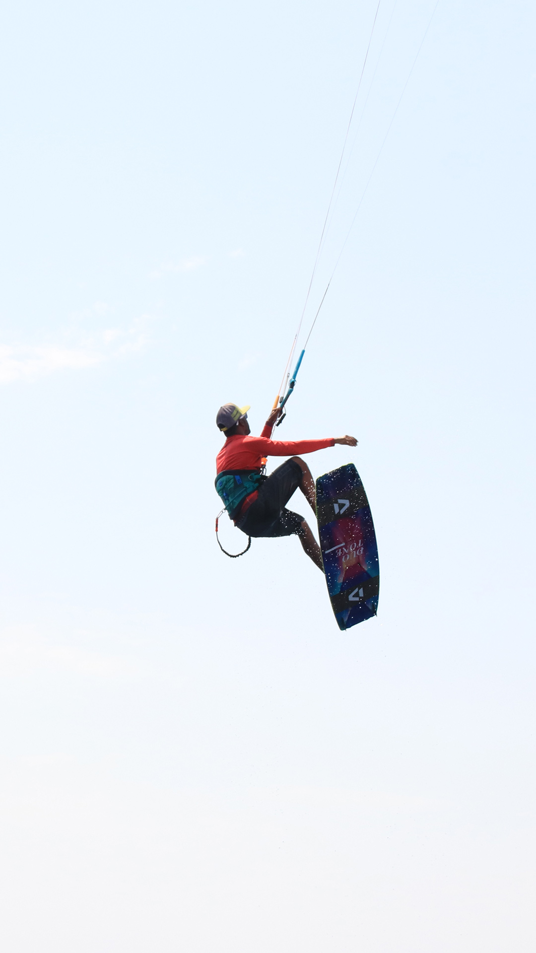 A kitesurfing instructor has jumped out and is now flying over the clear blue sky in the waters of the Safaga spot.