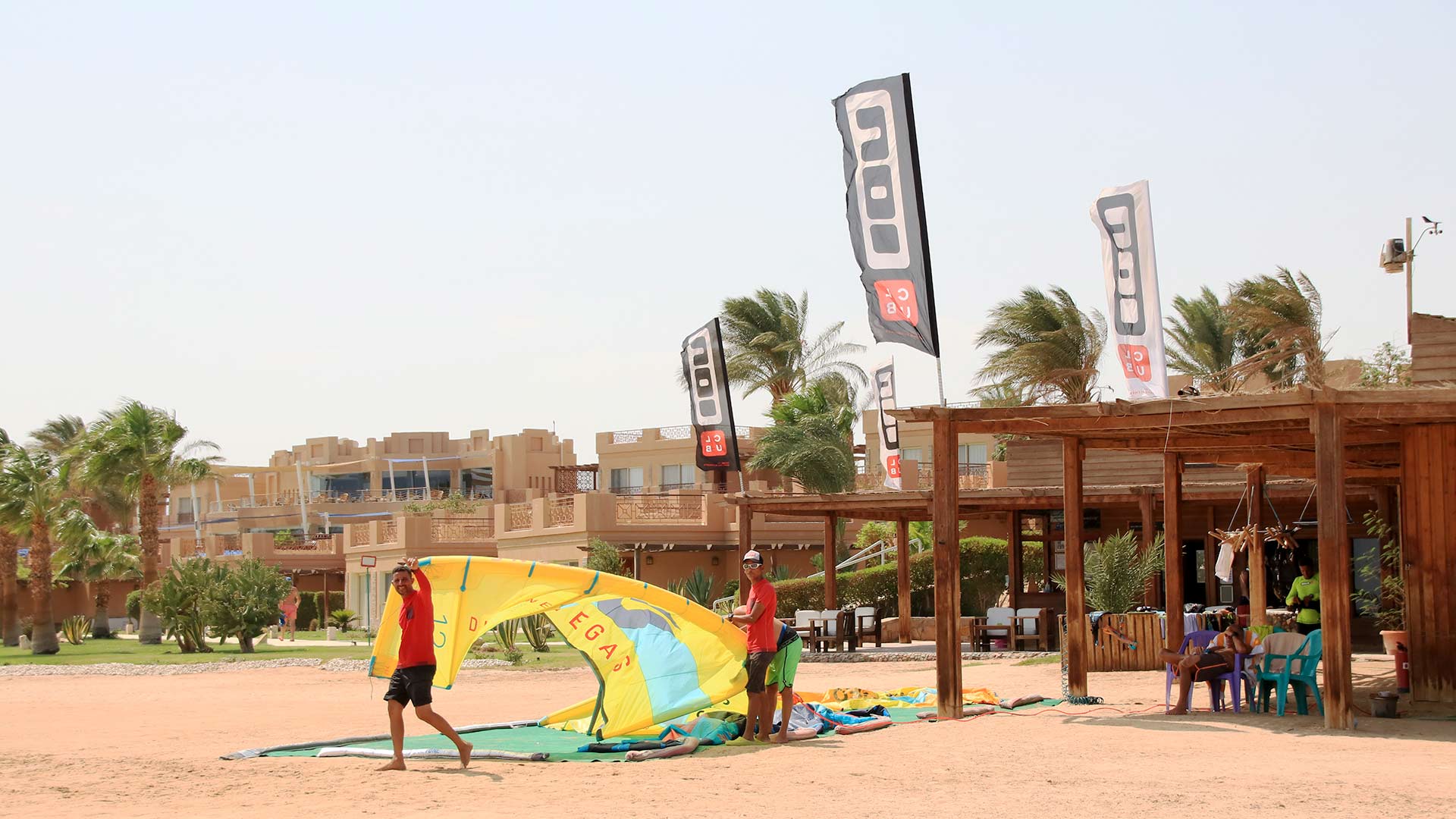 Vue latérale du centre de kitesurf Ion Club Safaga en Égypte, où deux membres de l'équipe préparent le matériel de kitesurf et nous accueillent. 