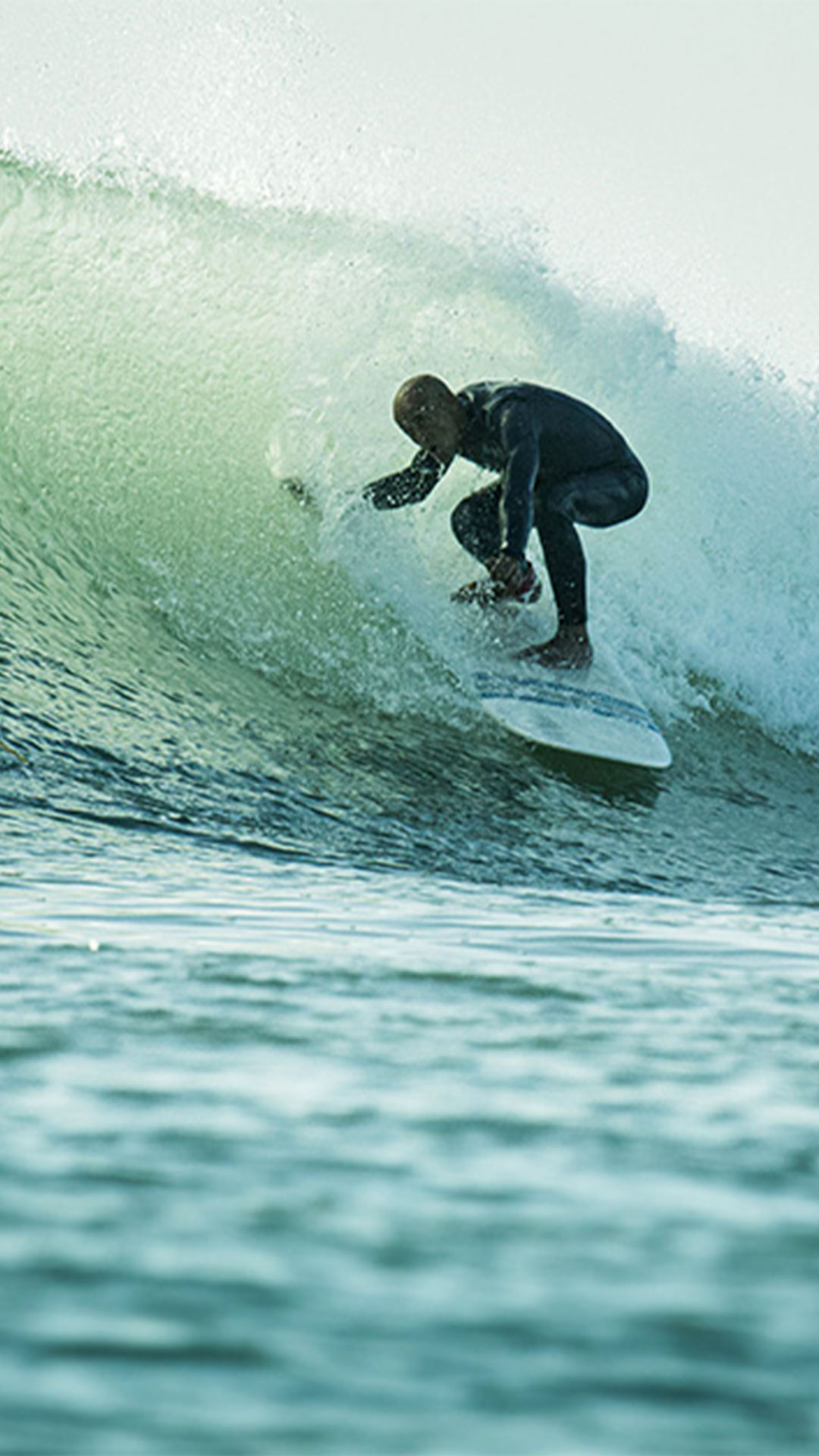 Un surfeur d'un niveau plus avancé surfe sur une grosse vague. 