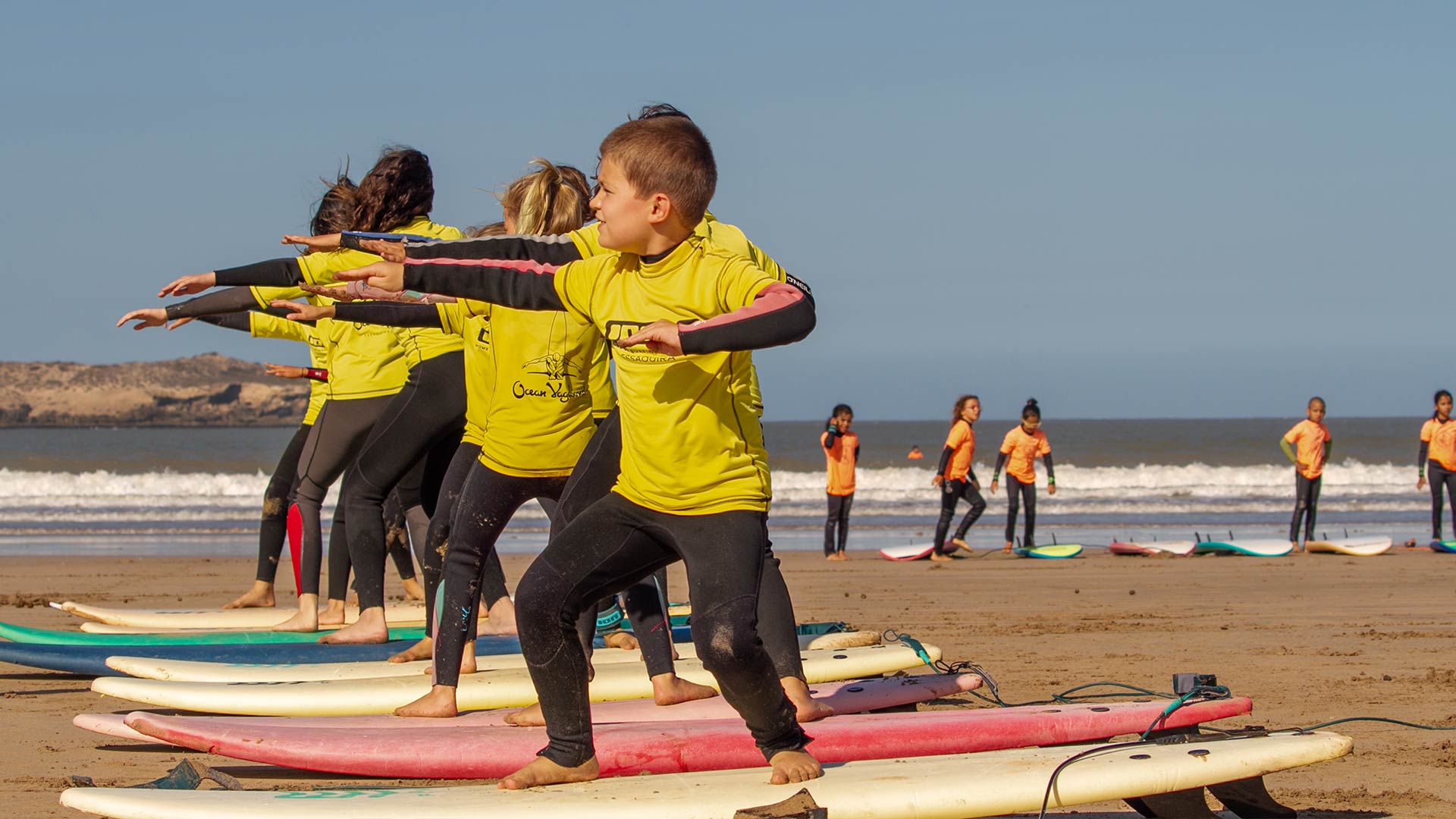 Surfing lesson on the beach with kids group