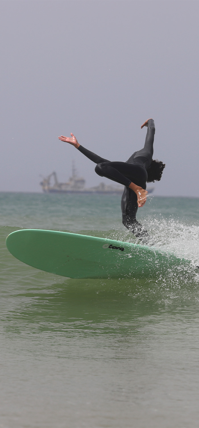 Un garçon tombe en surfant dans l'un de ses cours de surf. 