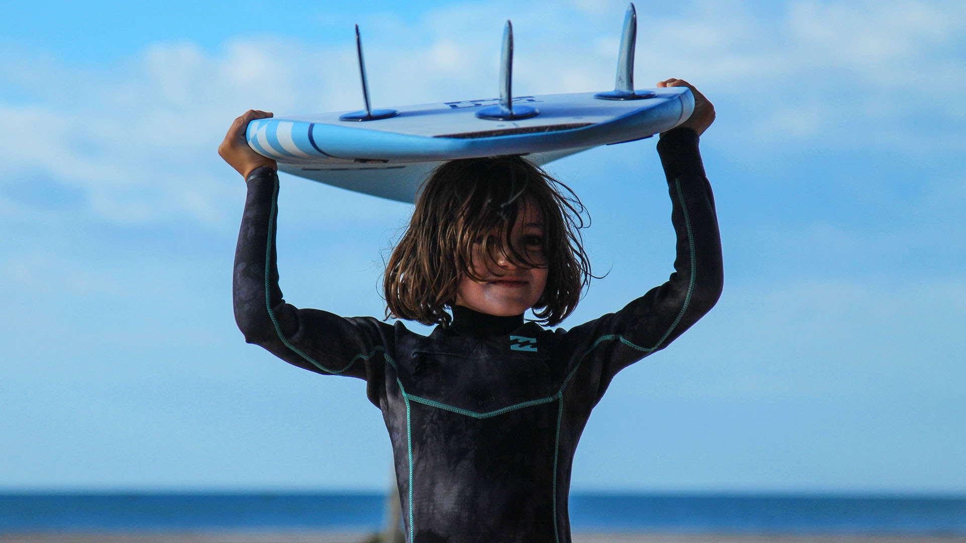 OV_babysitting child who doing surf with a blue sky