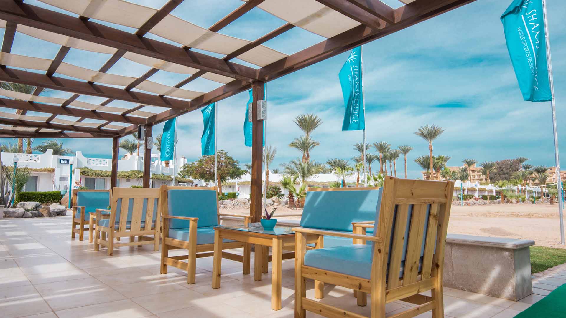 shams lodge terrace on the beach with flags