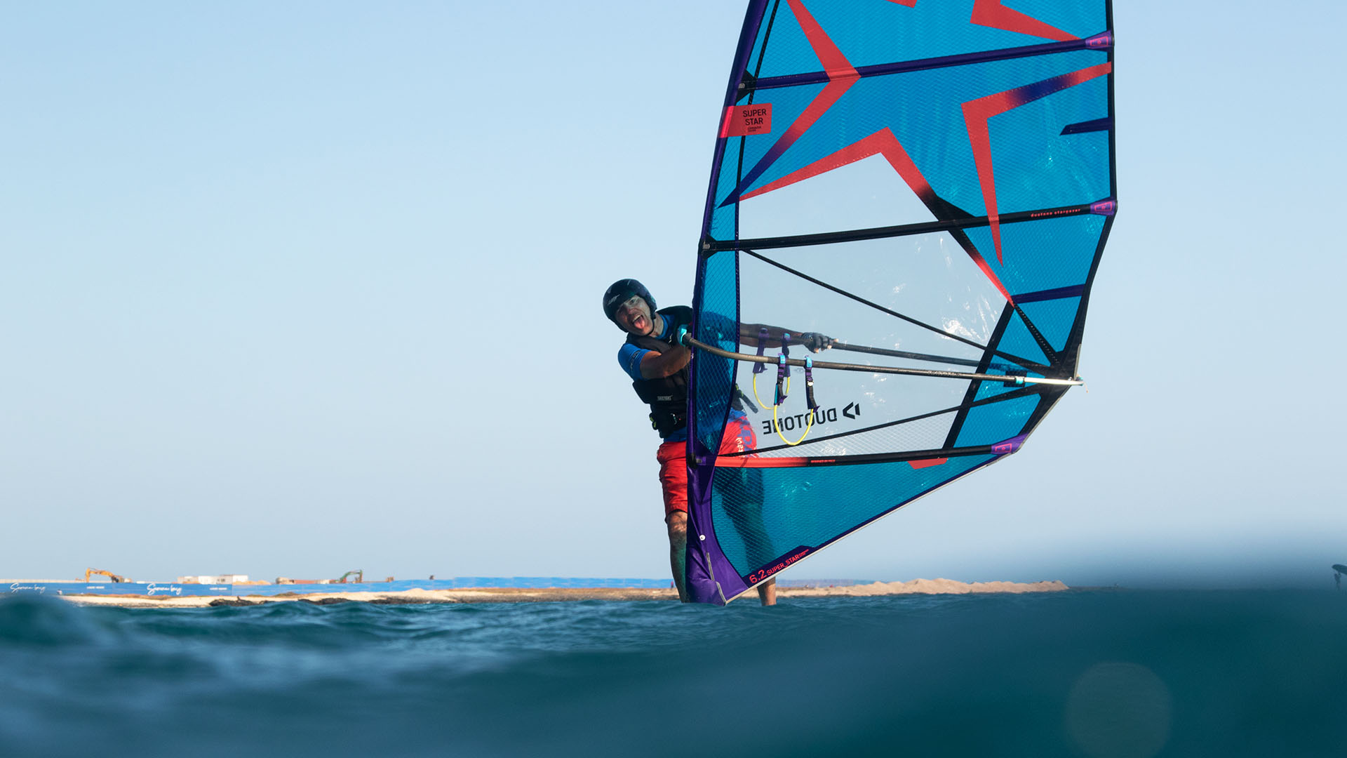 Seitenansicht der Kitesurfing-Station des Ion Club Safaga, wo zwei Mitglieder des Teams der Kitesurfing-Station die Kitesurfing-Ausrüstung vorbereiten und uns willkommen heißen. 