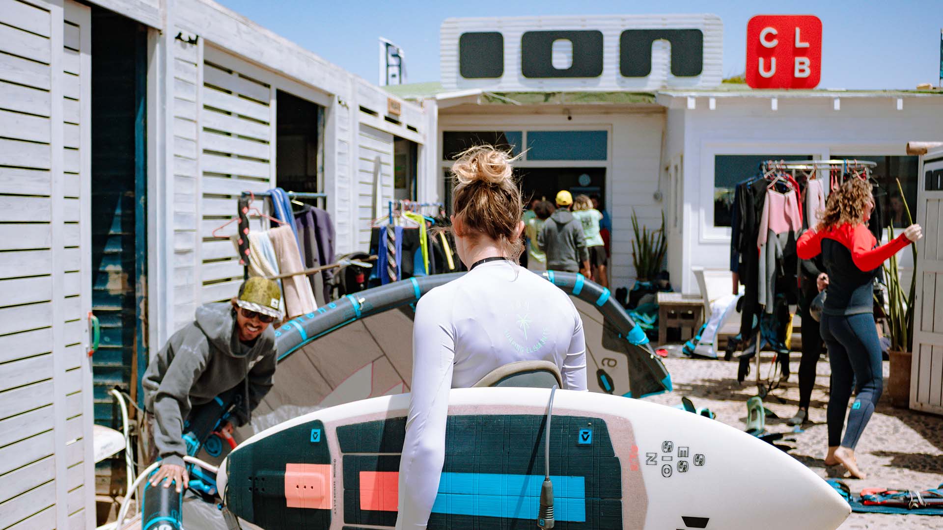 Voiles de windsurf posées sur le sol de sable blanc devant la réception du Ion Club Fuerteventura au spot de Risco del Paso.