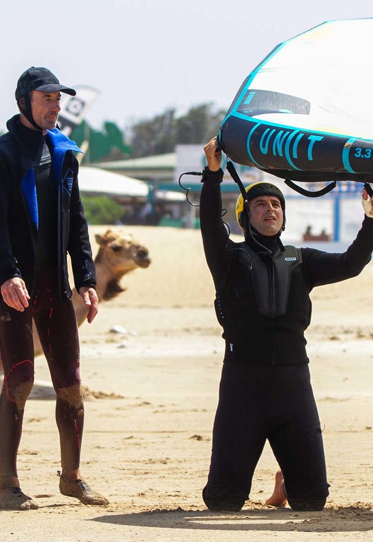 A child surfing his first waves in one of his course with a proud look on his face.