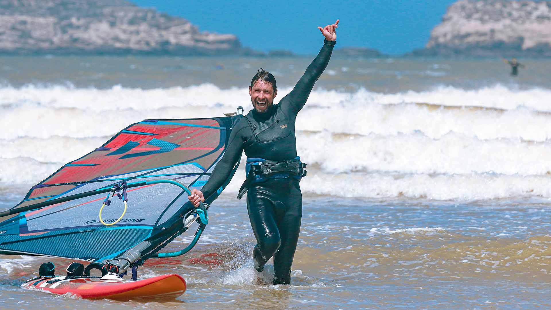 windsurf guy smiling in the ocean