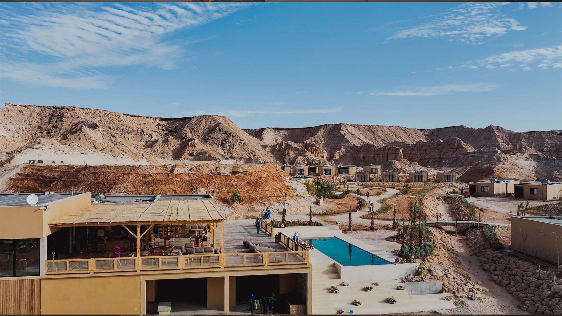 white dune canyon with a pool in the middle of the Sahara desert and dunes