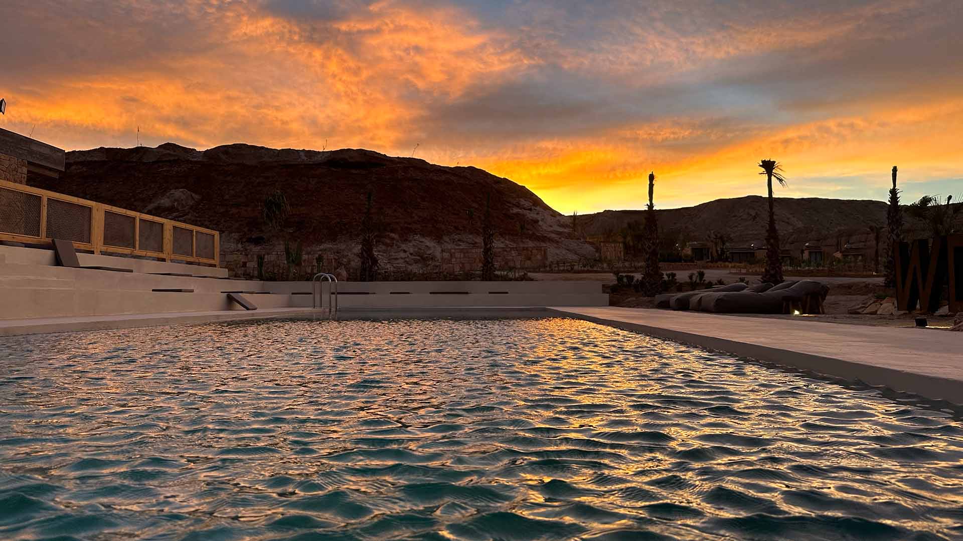 pool in the Sahara desert with a sunset