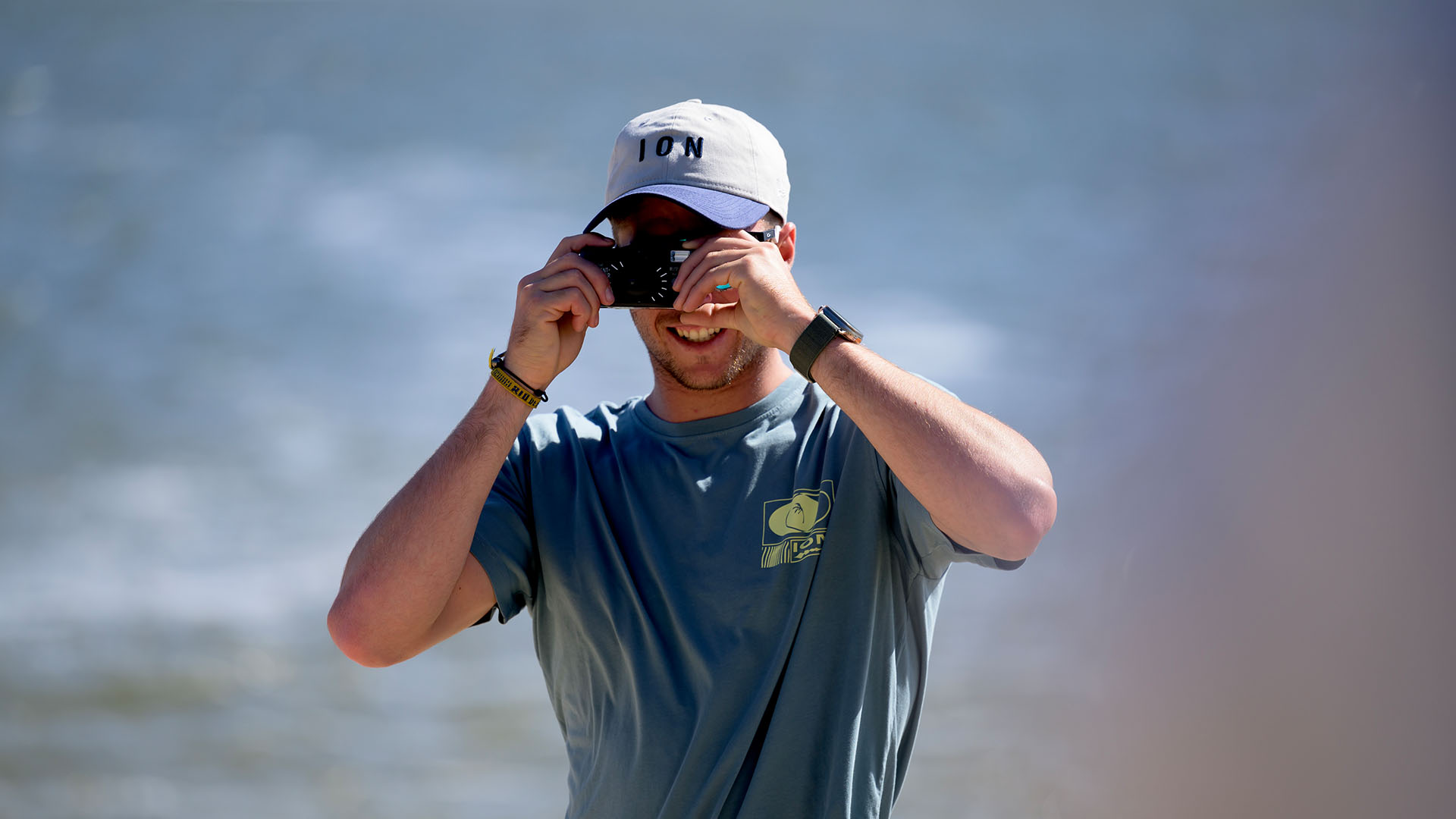 man with an ion cap beige and blue taking picture