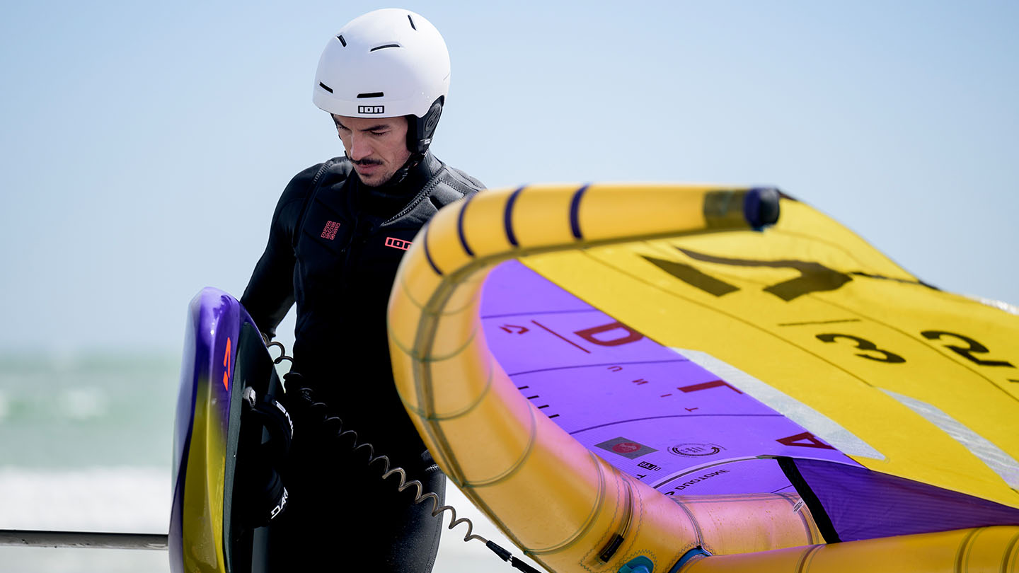 wingfoilers with an helmet white getting out of the water