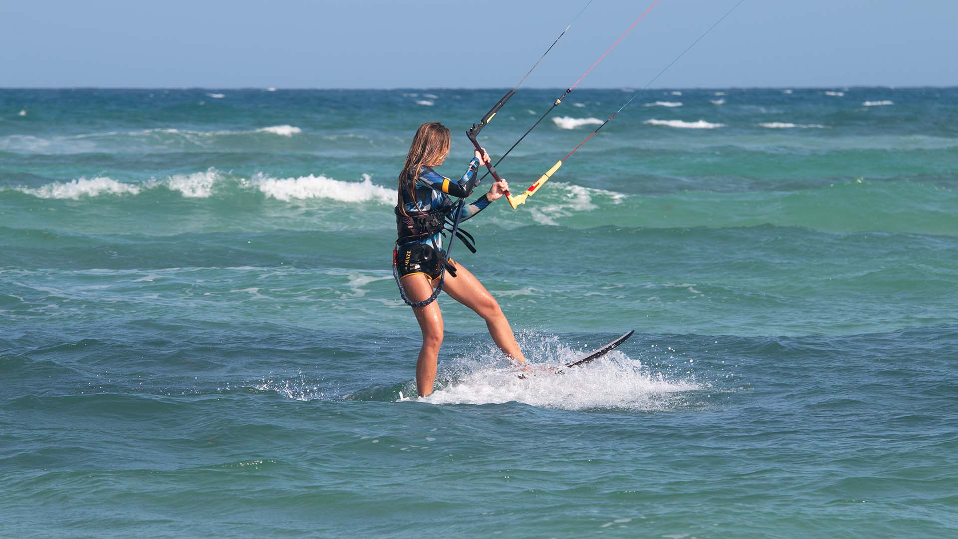 girl with an ion wetsuit on the beach with wind